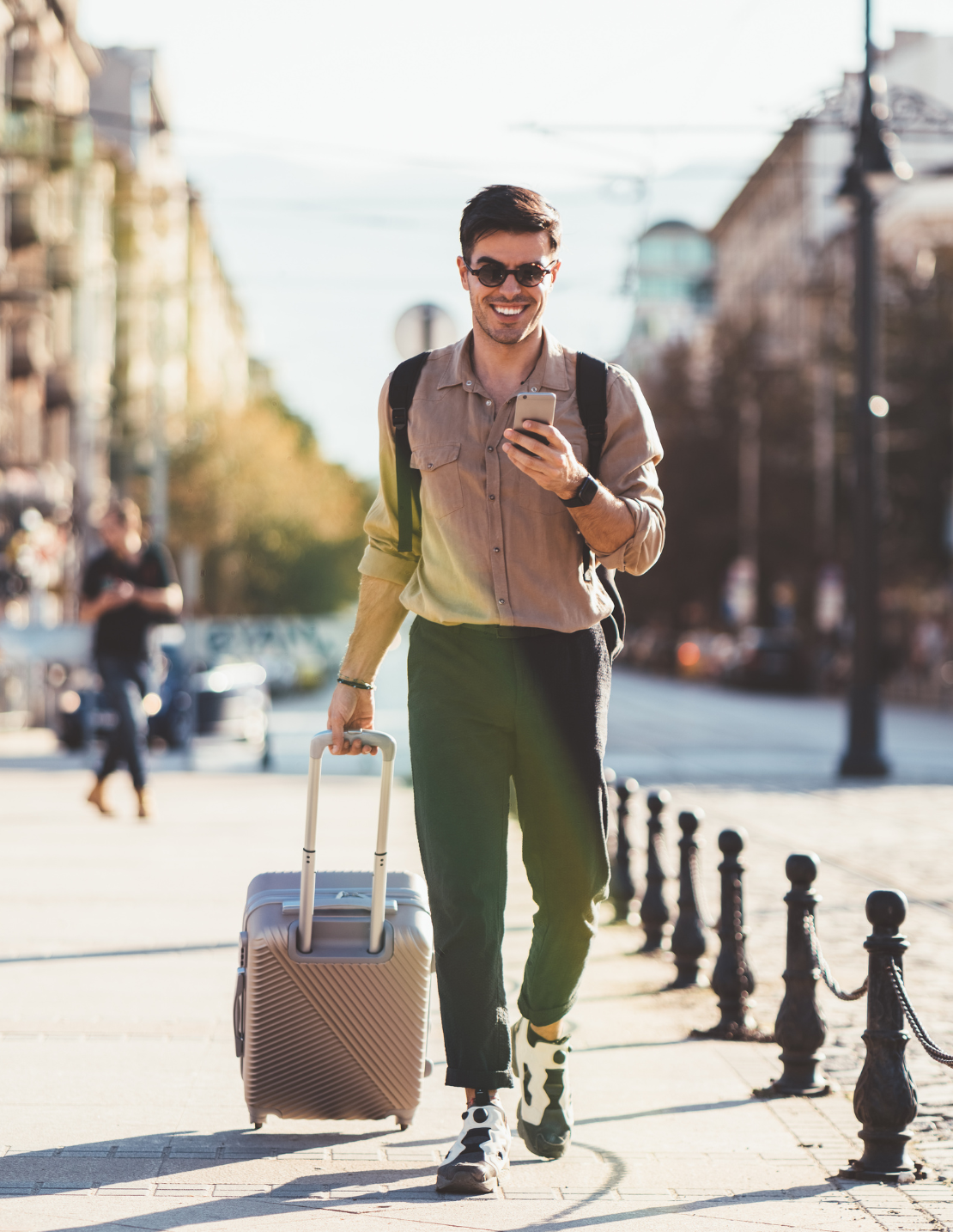 A man travelling with roller bag. A man happily travelling happily with luggage.